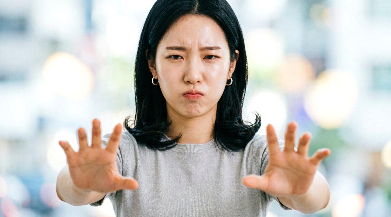 書類を持ちながら一歩下がる女性と、驚いた表情の男性