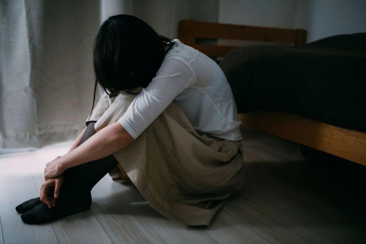 夜中に元カレのことを思い出して悲しむ女性。復縁と諦めの間で悩む失恋後の孤独な心情をイメージした画像