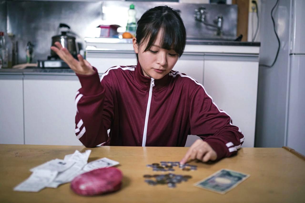 相談窓口の電話をかける女性、安心した表情のクローズアップ