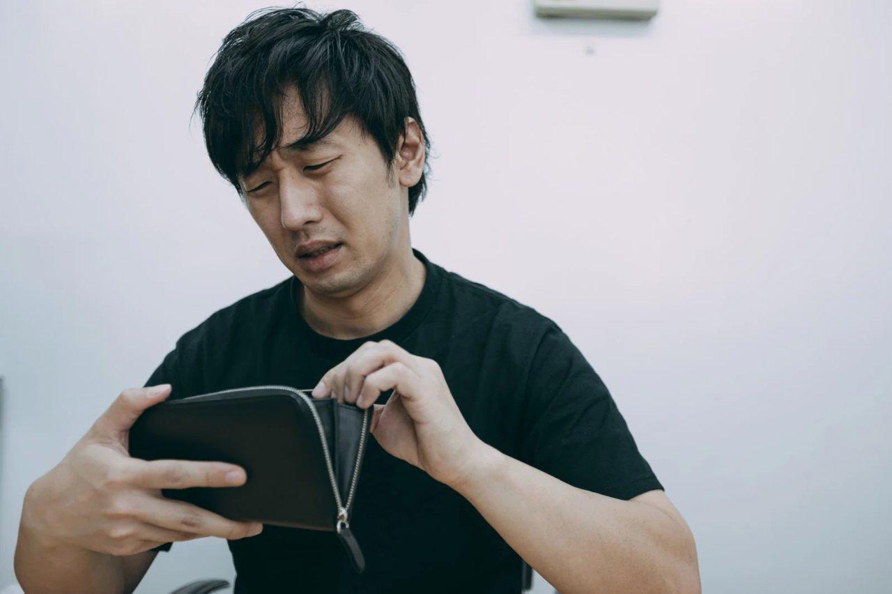 ペンとノートに日時と発言を記録する女性と、後ろで話し合う同僚たち