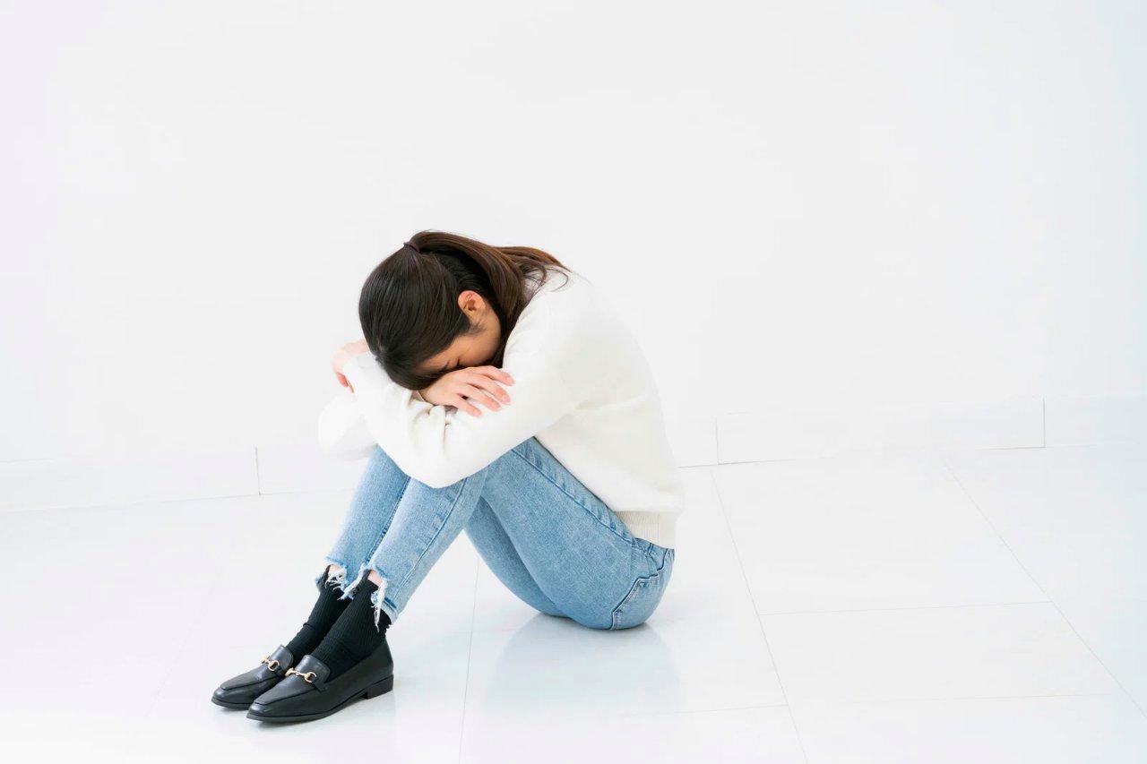鏡に映る自分を見つめながら、過去の恋人と比較して悩む女性の表情