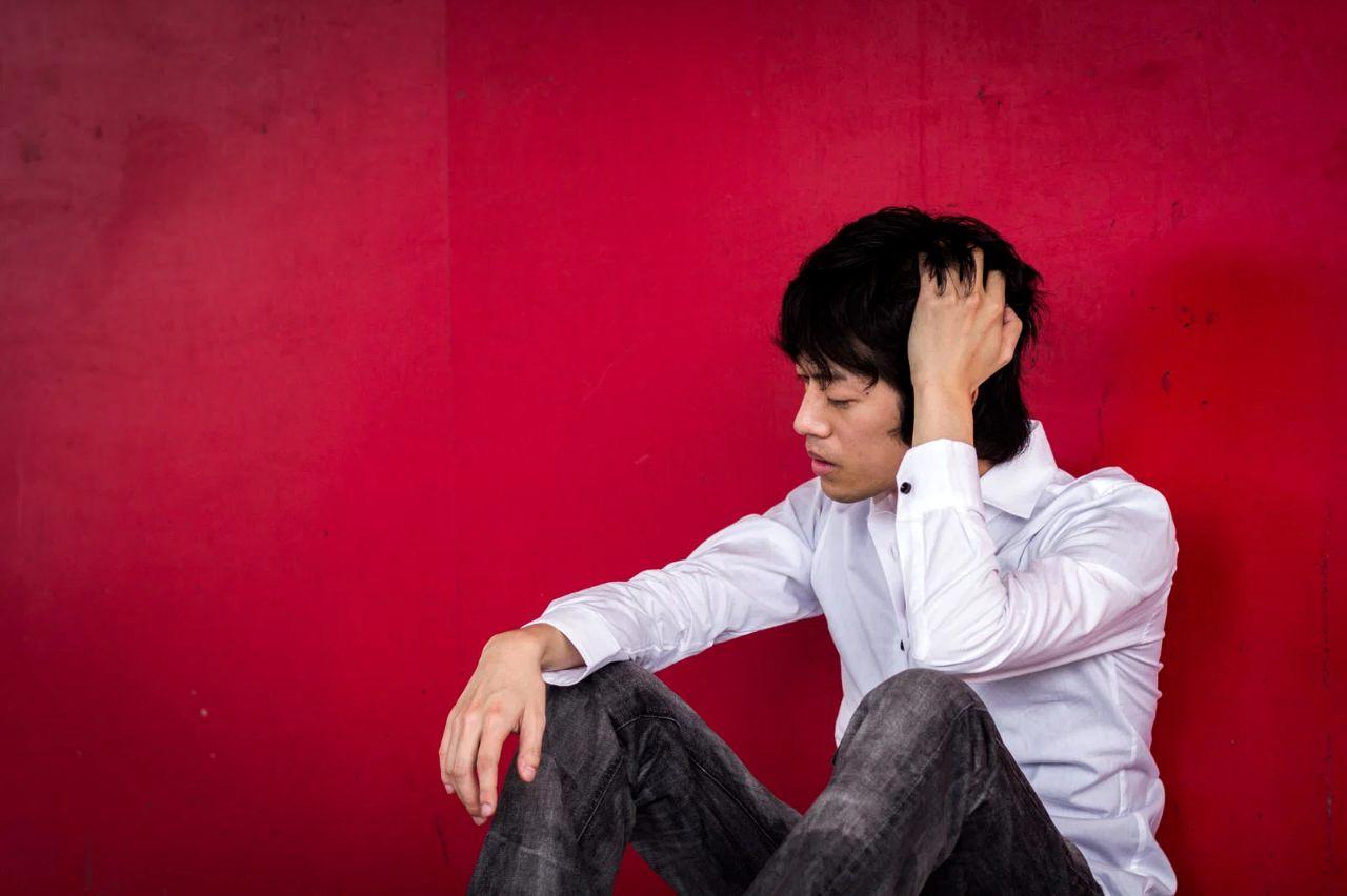 職場で髪を触られ、思わず強く拒絶してしまい気まずくなる女性の様子