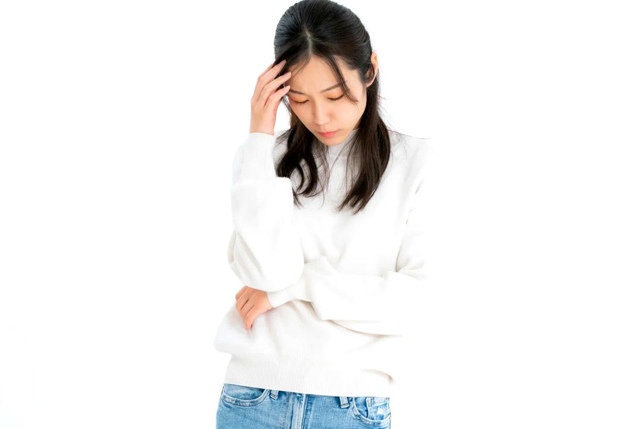 スマートフォンを手に、迷いながらメッセージを開く女性の手元のクローズアップ