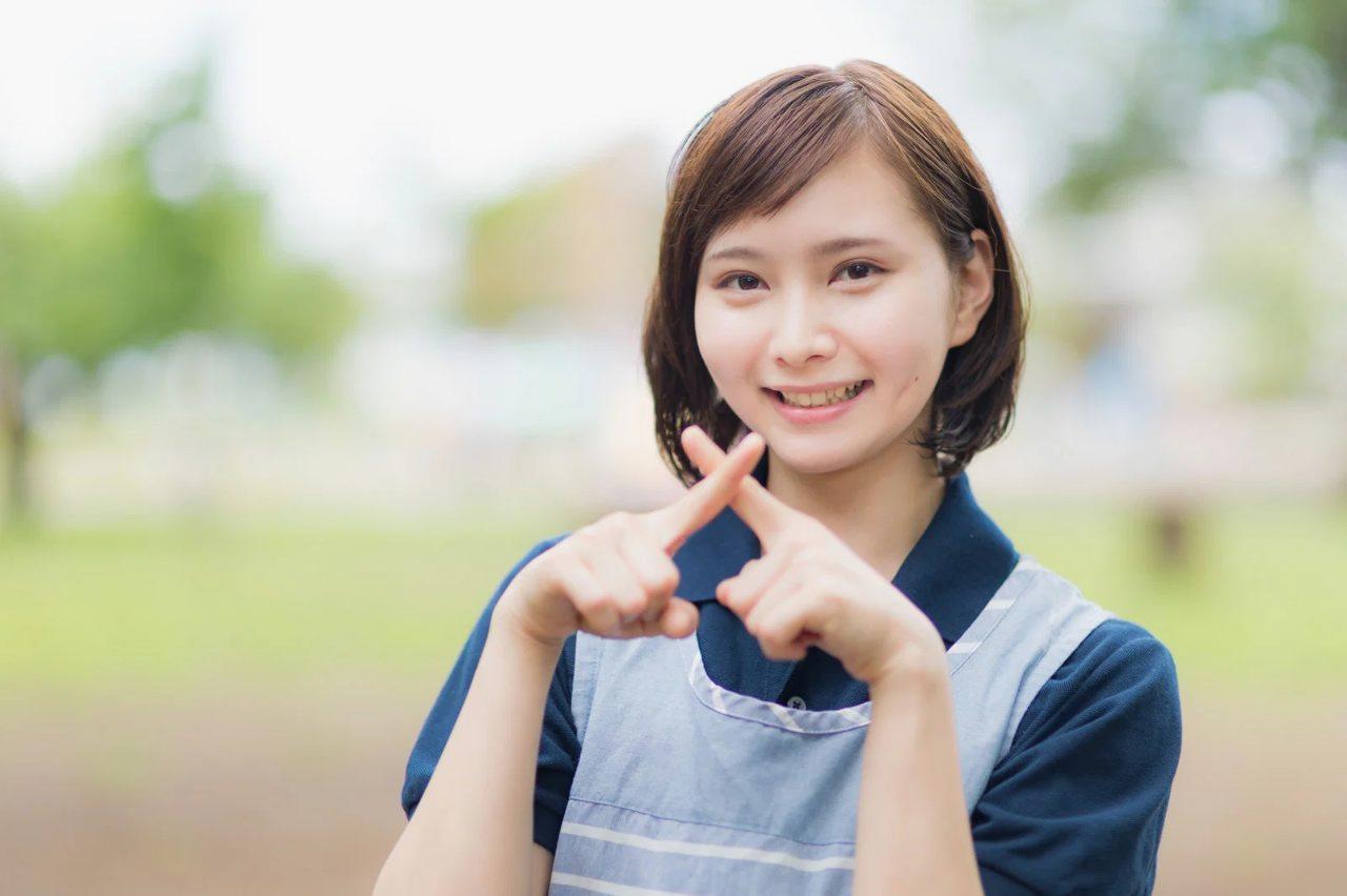 スマホに視線を戻しながら短く一言返事をする女性のイラスト