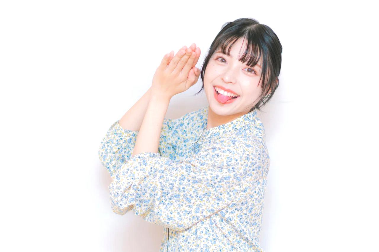 穏やかな笑顔を見せながら手のひらでストップサインを示す女性