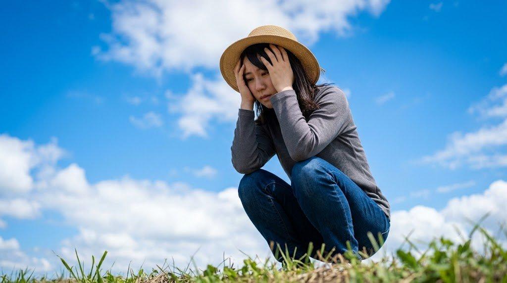 悩む女性の後ろ姿と、頭に手を伸ばす男性のシルエット
