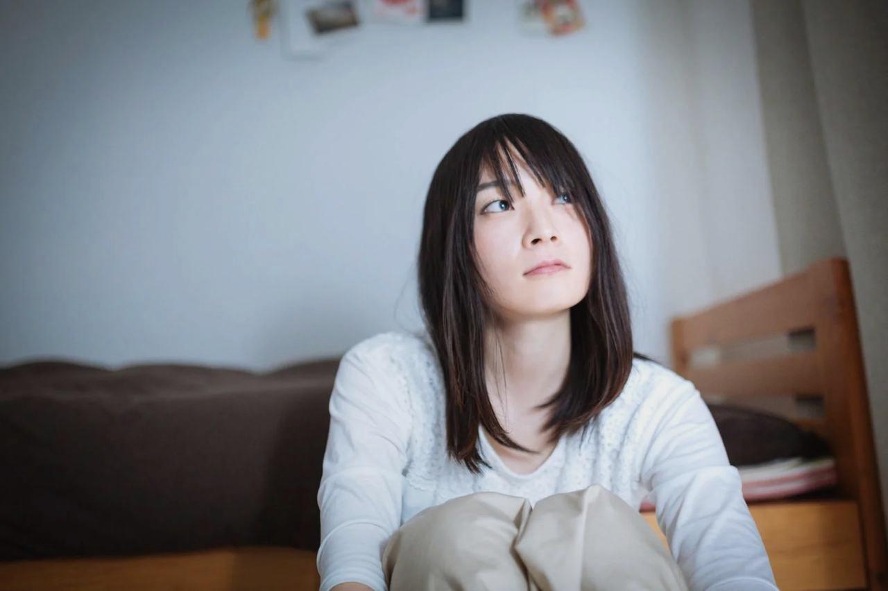 鏡を見つめながら、自分の本当の気持ちを問いかける女性の横顔